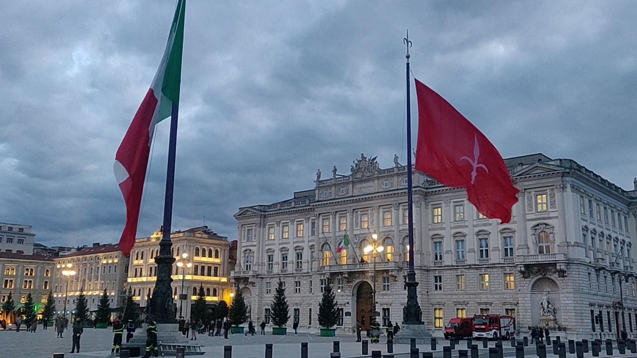 Trieste, il vento e l'ammainabandiera nella spettacolare cornice di piazza Unità