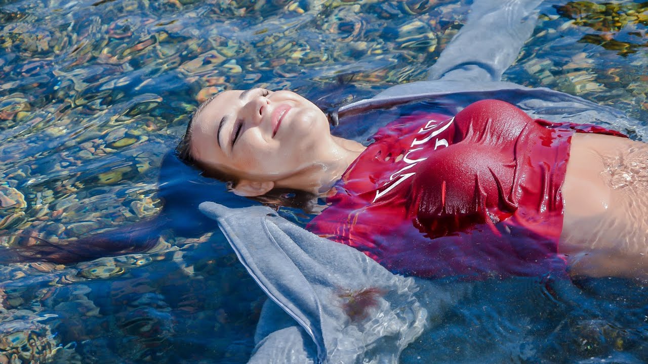 SUMMER WETLOOK: A CURVED GIRL POSE COOLLY IN WET CLOTHES ON THE SEASHORE, SWIM IN CLOTHES AND RELAX