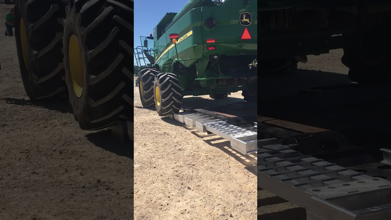 John Deere S680 loading onto a Landoll 845HD-AG trailer.