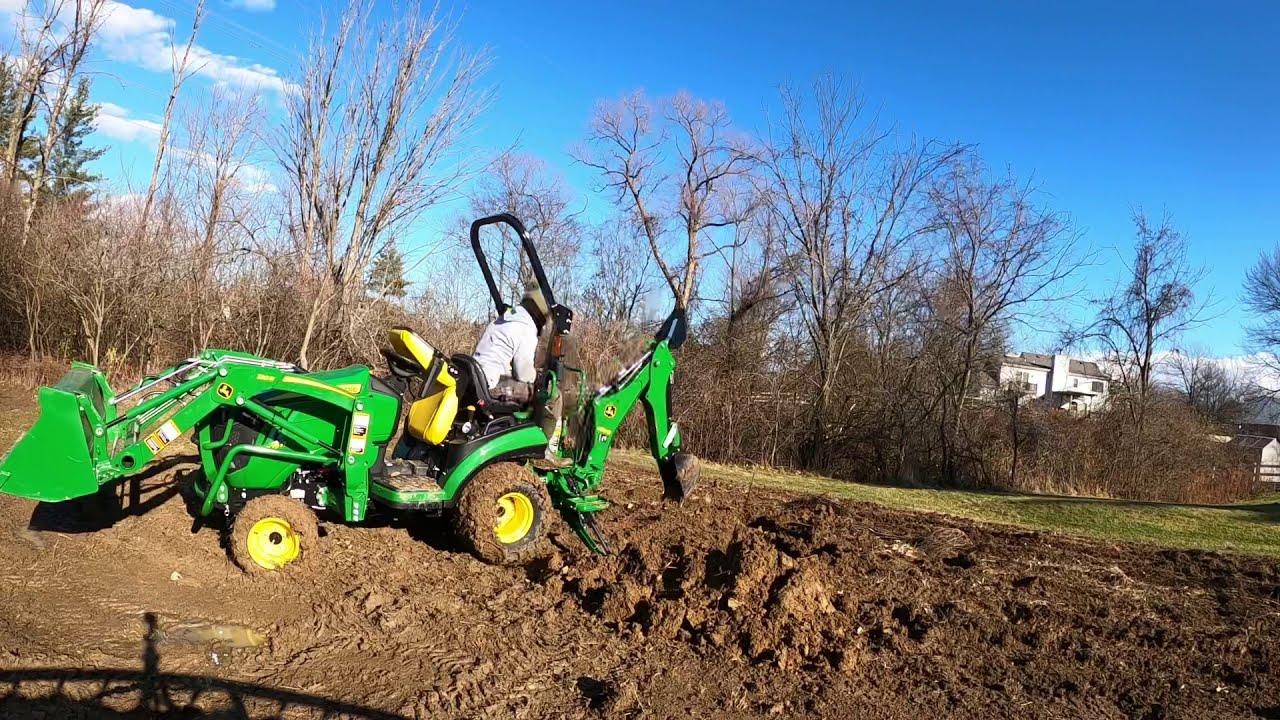 John Deere 1025R, первый день работы с экскаватором-погрузчиком 260, копание ям, изучение управле...
