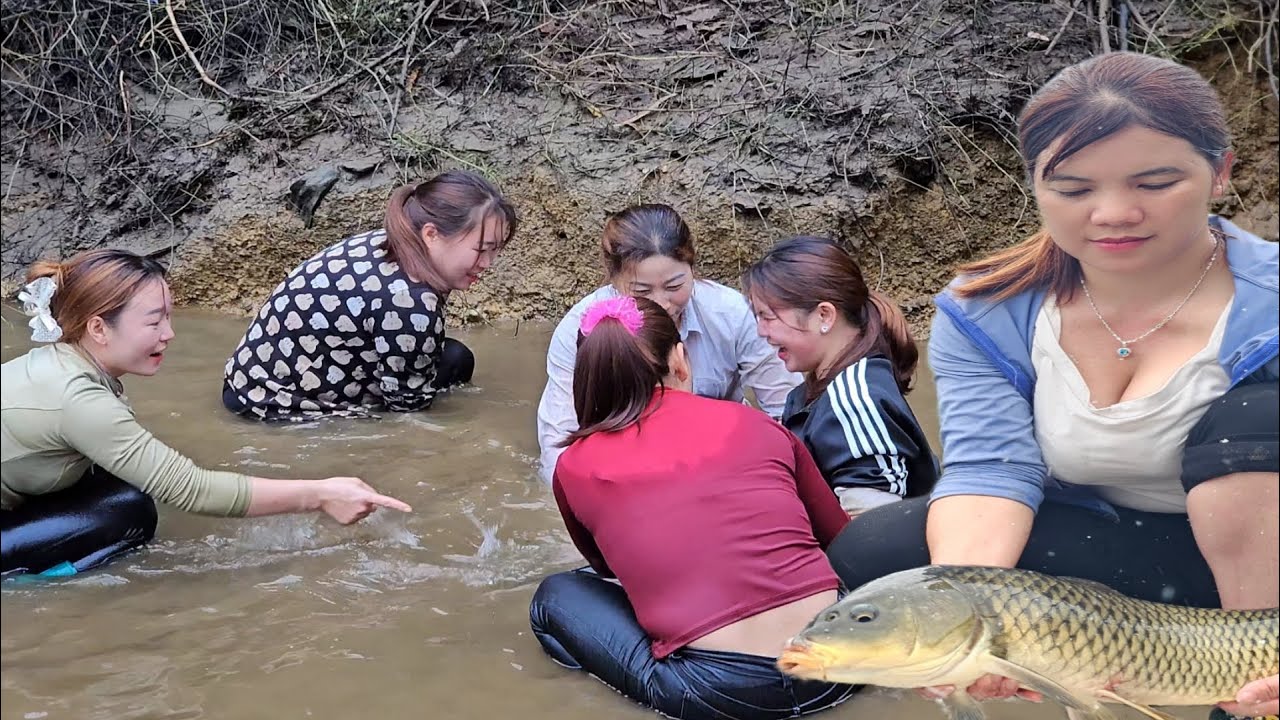 The lake water receded quickly, and the girl on the lake dammed the stream to catch big fish.