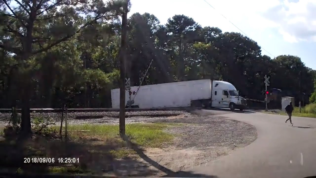 Semi-truck split in half by train
