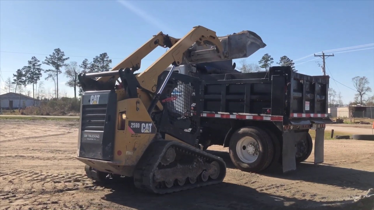 Cat 259D skid steer loading Mack dump truck