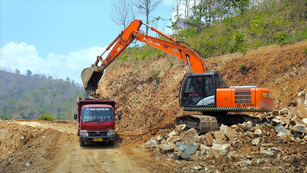 Watch Hitachi Zaxis 200 Tear Down Mountain & Load Dirt Trucks