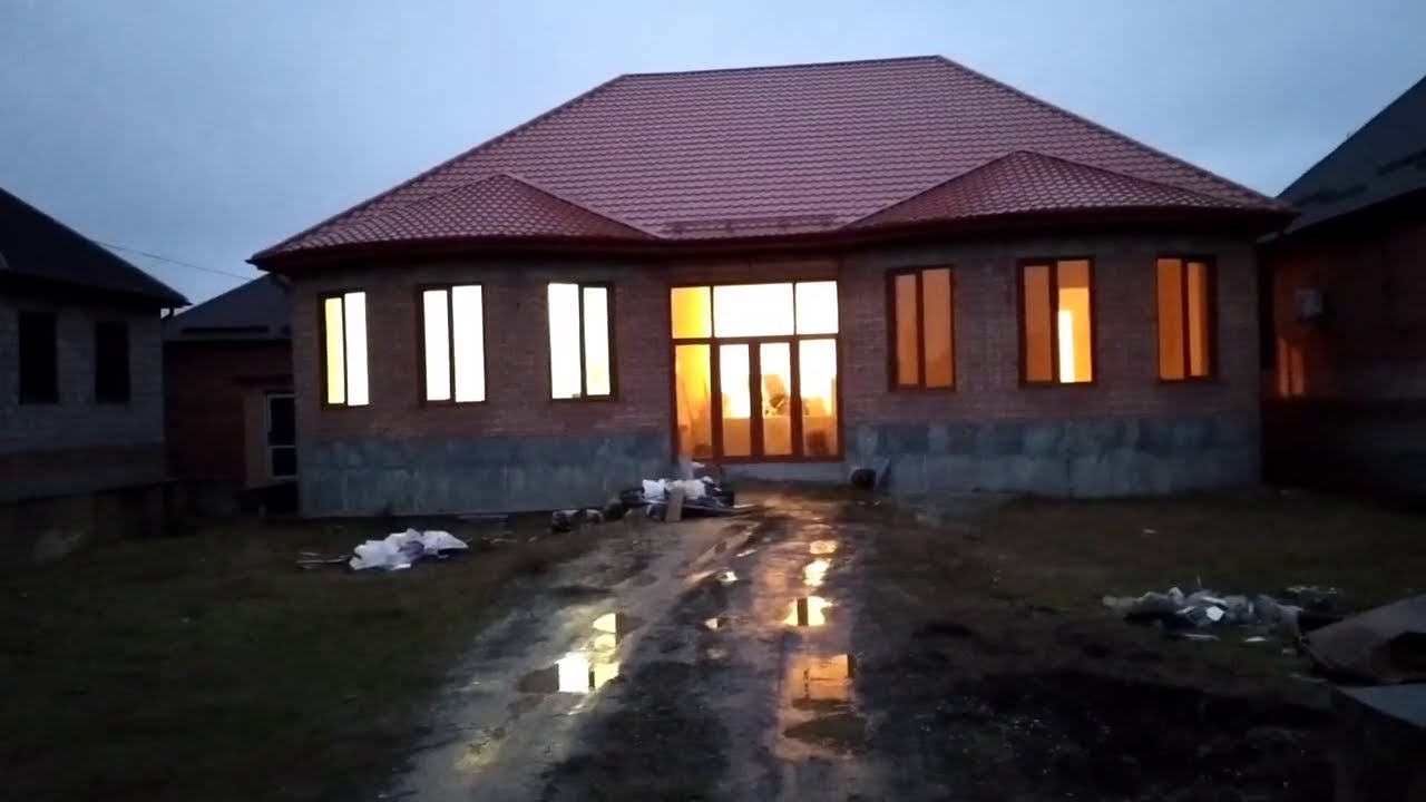 Большой одноэтажный кирпичный дом с двумя полукруглыми эркерами