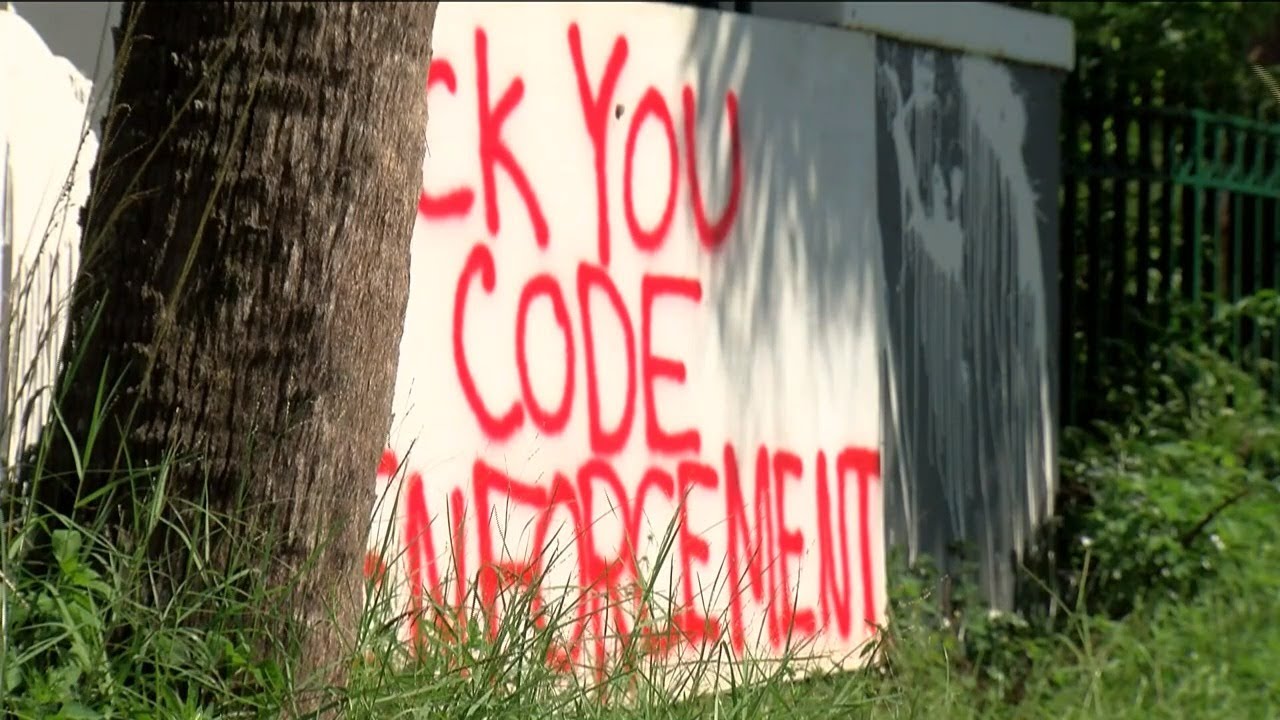 Signs cursing out Fort Myers Code Enforcement removed from riverside property