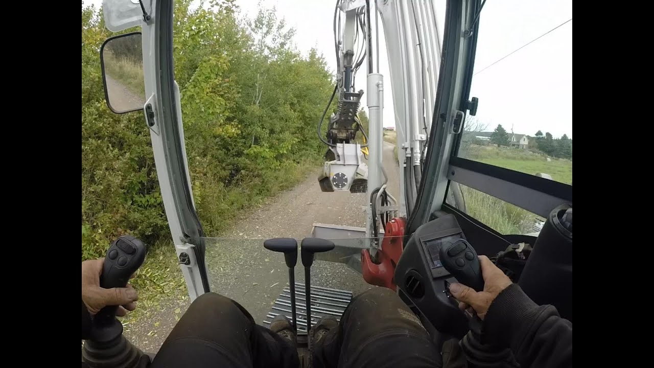 Excavator mulching roadside vegetation.
