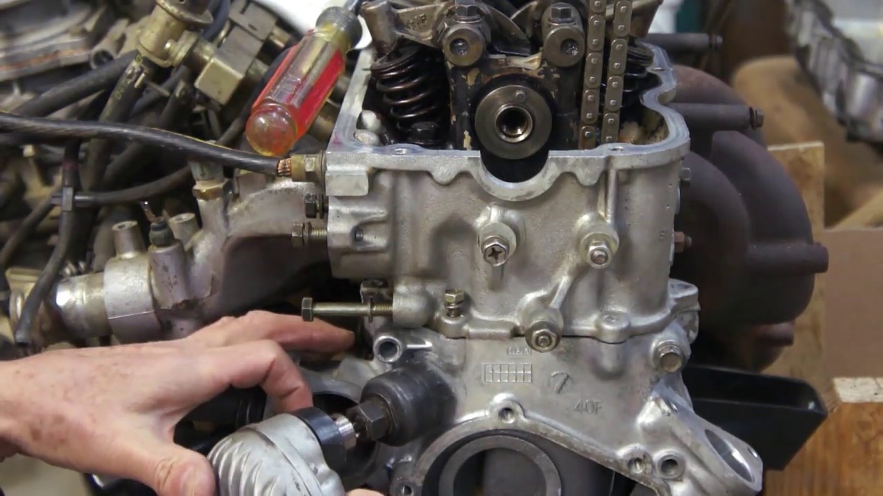Устранение стука при запуске двигателя Nissan KA24E через отверстие доступа к крышке цепи ГРМ.