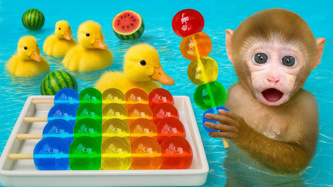Mono BeBe adorable se baña con el patito en la piscina y come caramelos de gelatina coloridos!