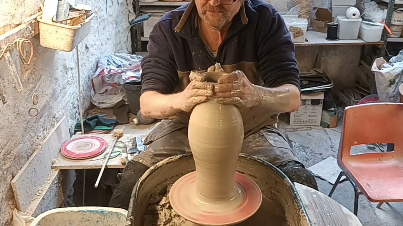 Making a taller pottery vase on the wheel.