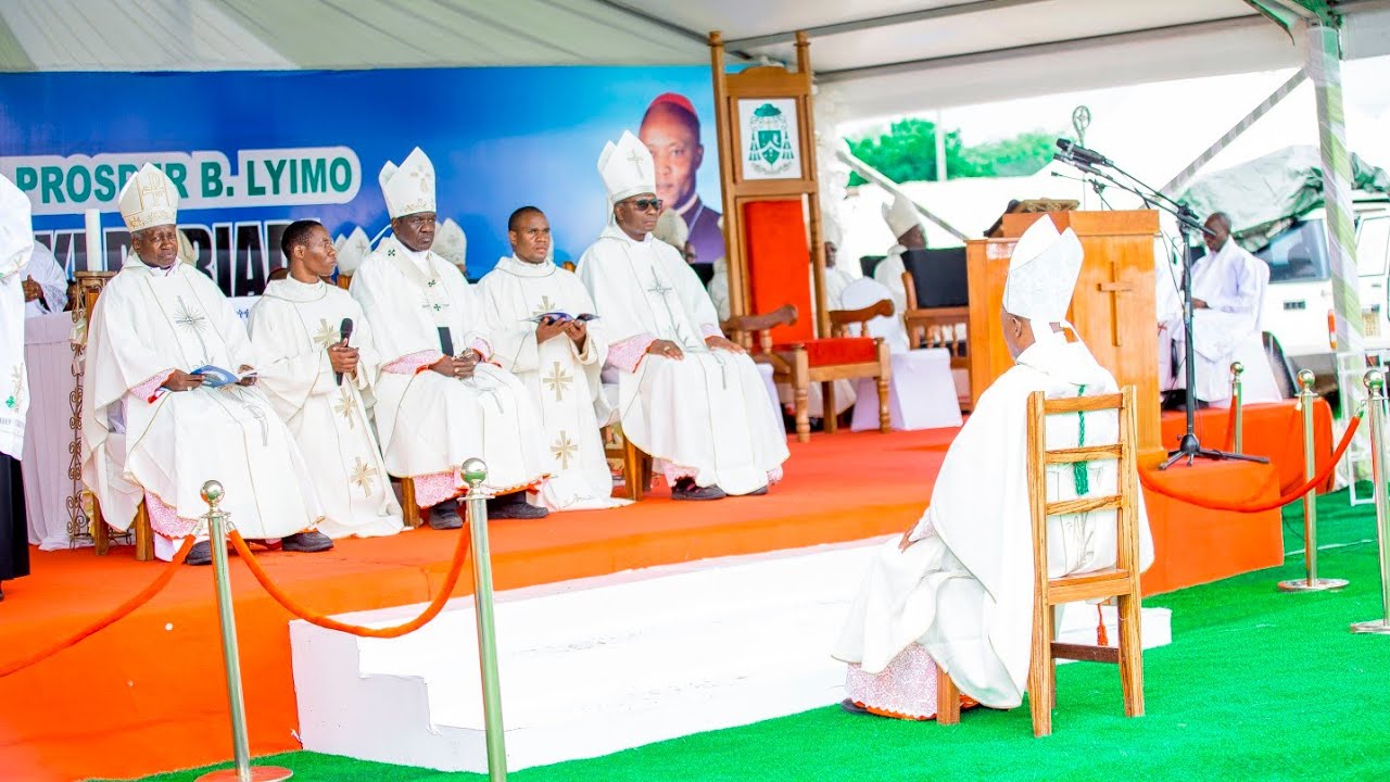 BISHOP PROSPER IS QUIET IN FRONT OF THE ALTAR WHILE THE HOLY FATHER'S AMBASSADOR READS THE ORDER ...