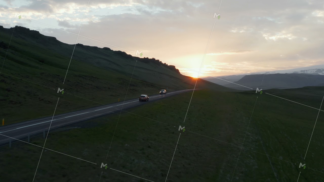 Aerial view of ring road in Iceland with fast driving car at sunset. Top view from drone of highway