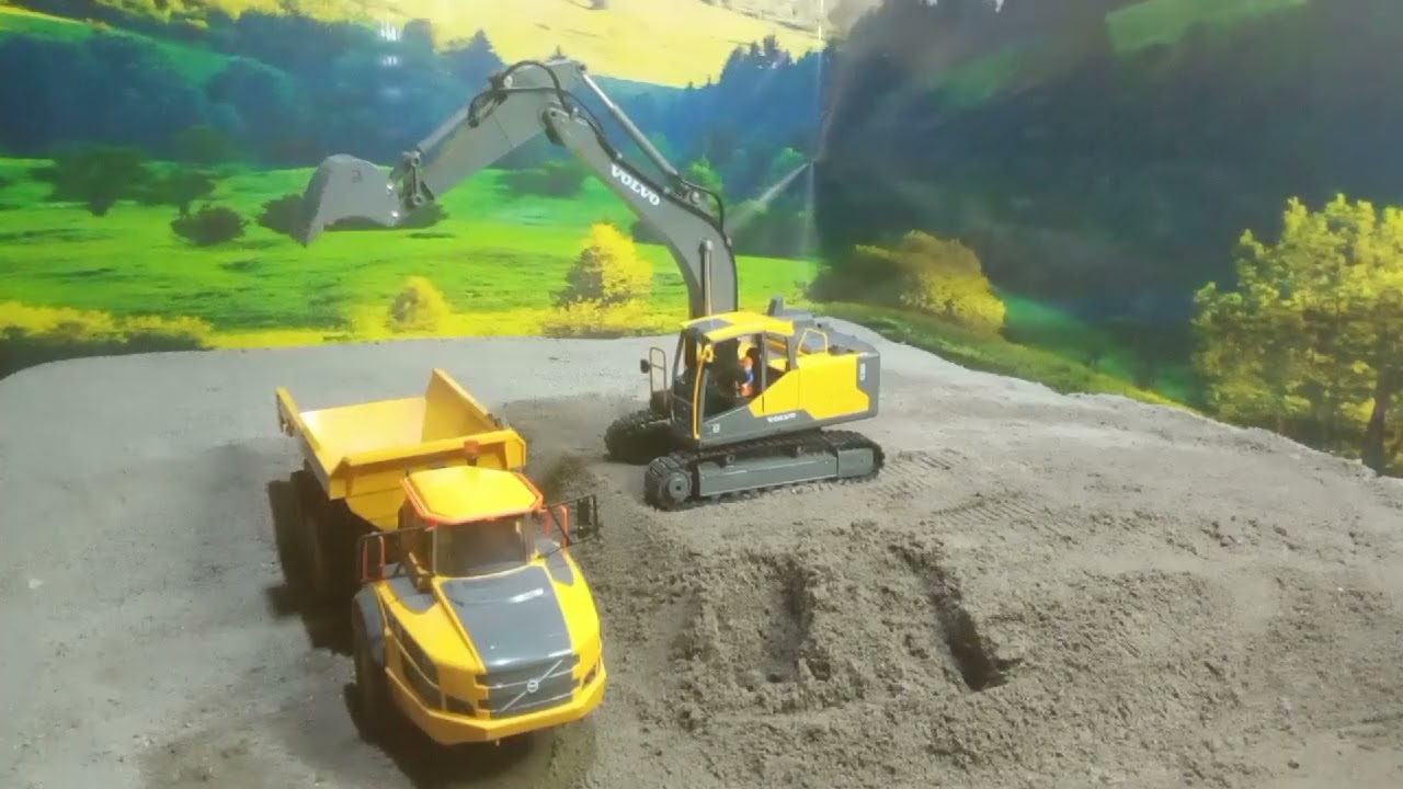 Rc excavator mining sand with Rc dump truck at mine site.