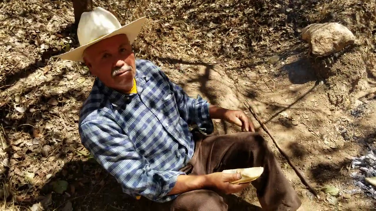 calentando unos tacos en las brazas en el cerro