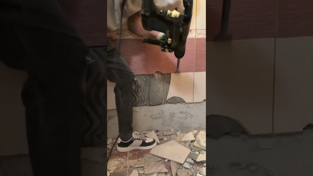 o pedreiro est&aacute; trabalhando na reforma da casa e usando um martelete da Makita