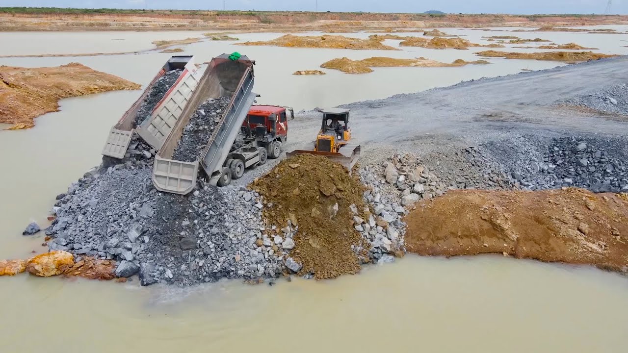 Activities Build Road In Deep Pit Use Techniques Bulldozer and Dump Truck Spreading Stone into Water