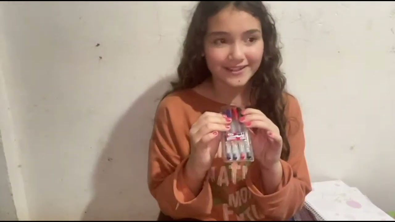 Marya Klara mostrando os materiais de escola dela.