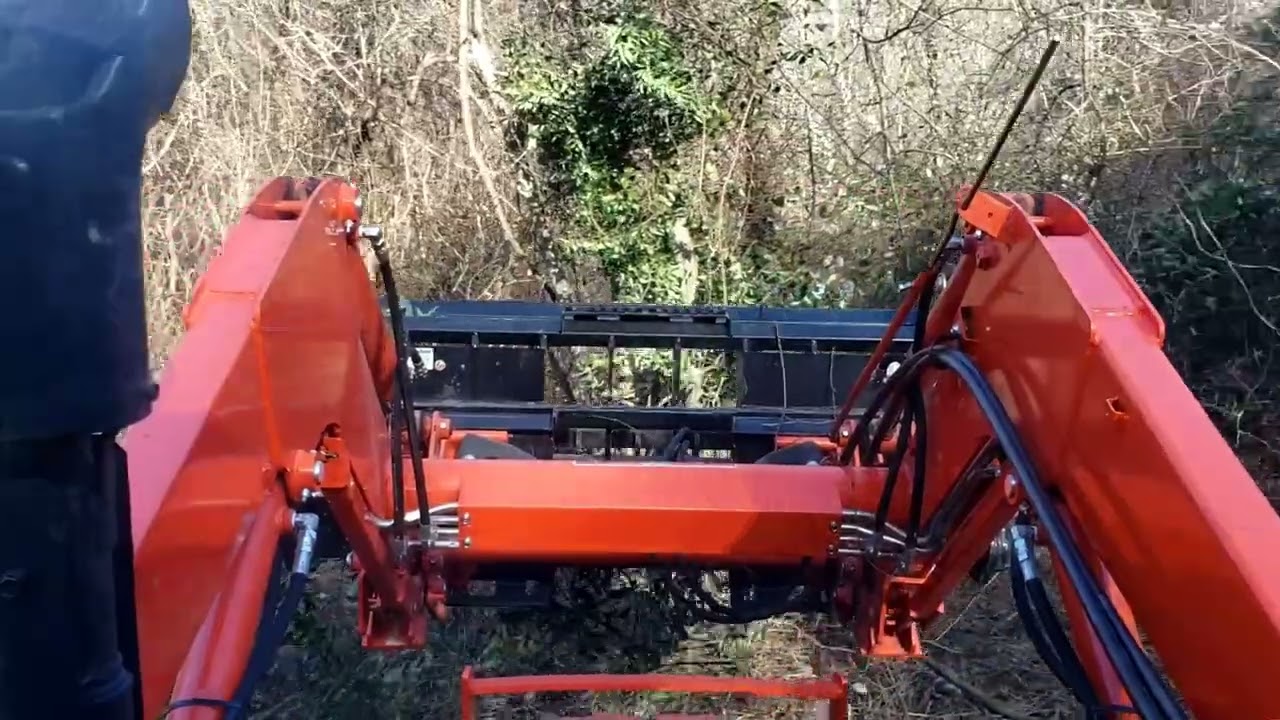 Clearing land with a tractor, grapple, and brush hog.