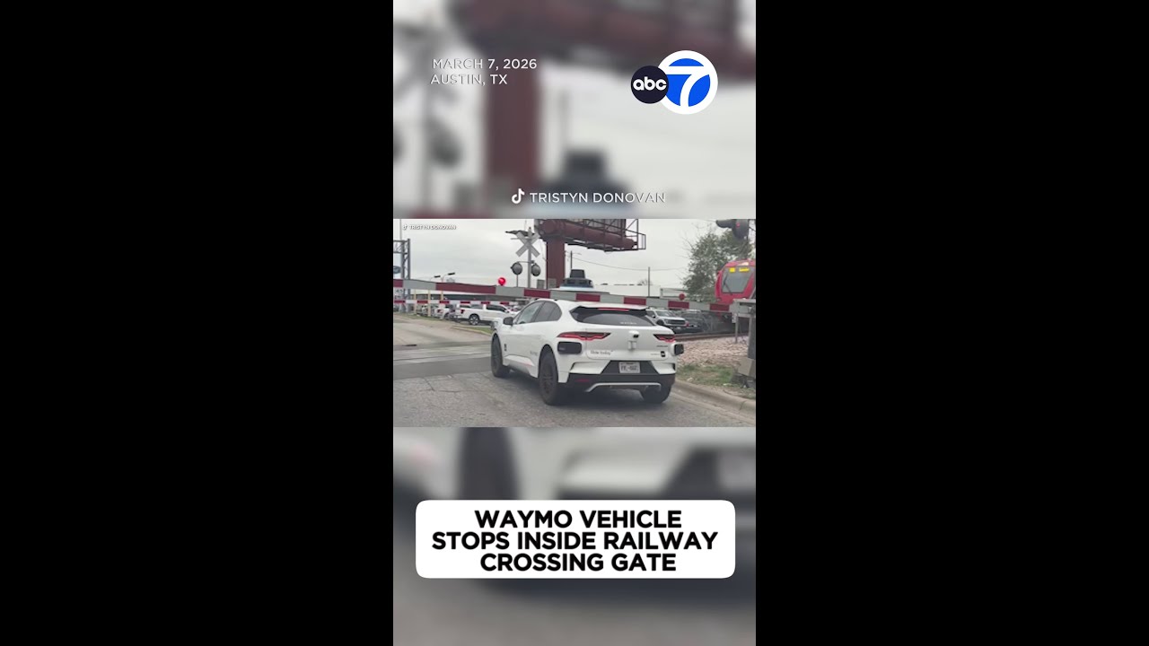 Waymo останавливается внутри шлагбаума железнодорожного переезда.