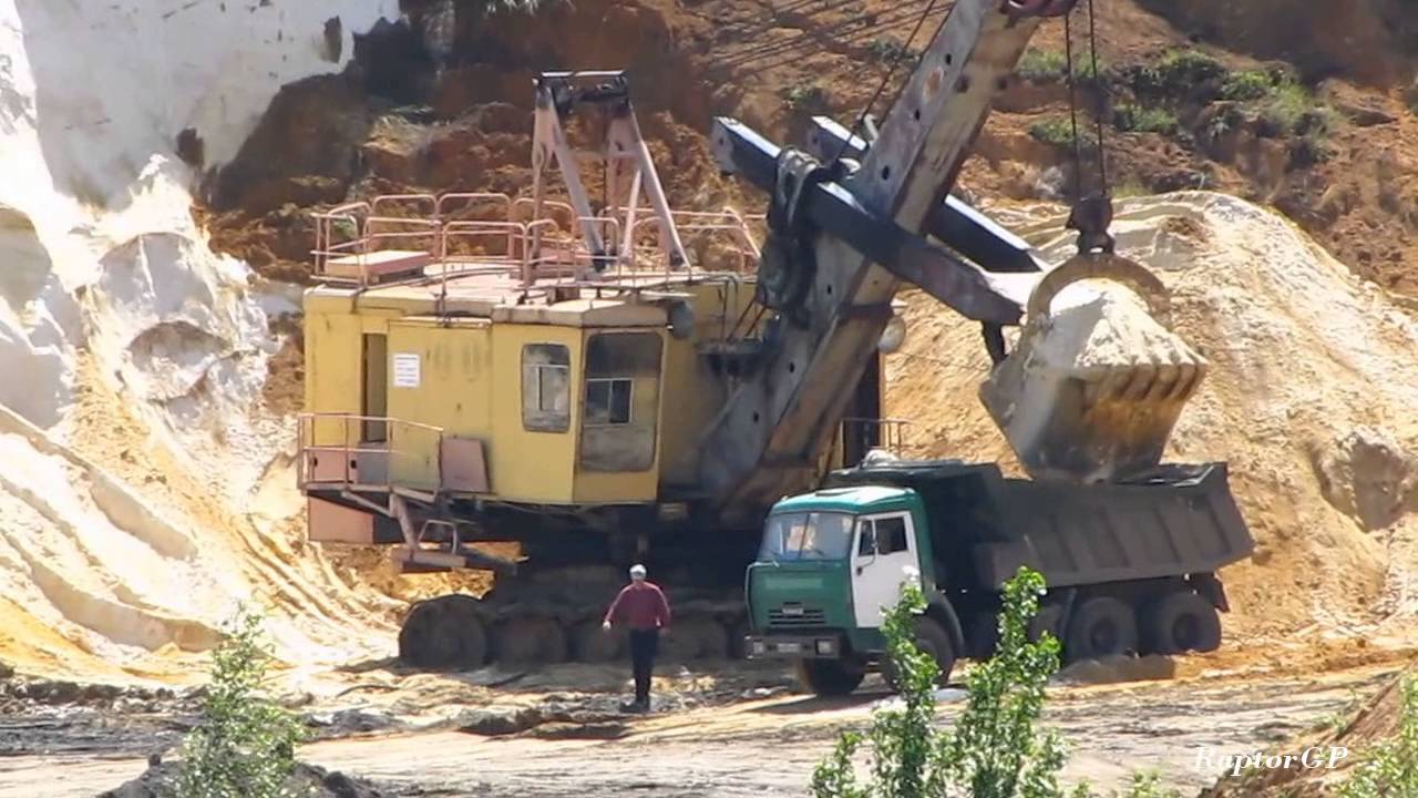 EKG-5 shovel loads dump trucks in sand quarry. ЭКГ-5 загружает самосвалы песком