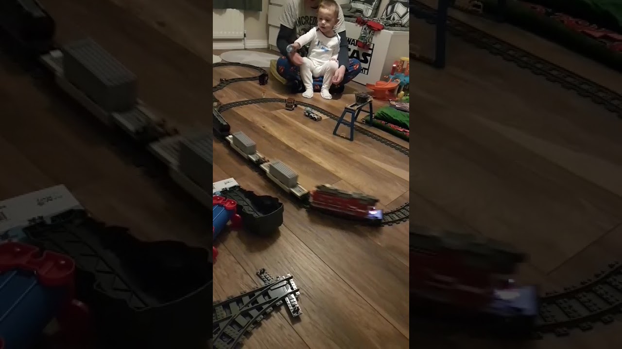 Dad and big brother make a large lego train set
