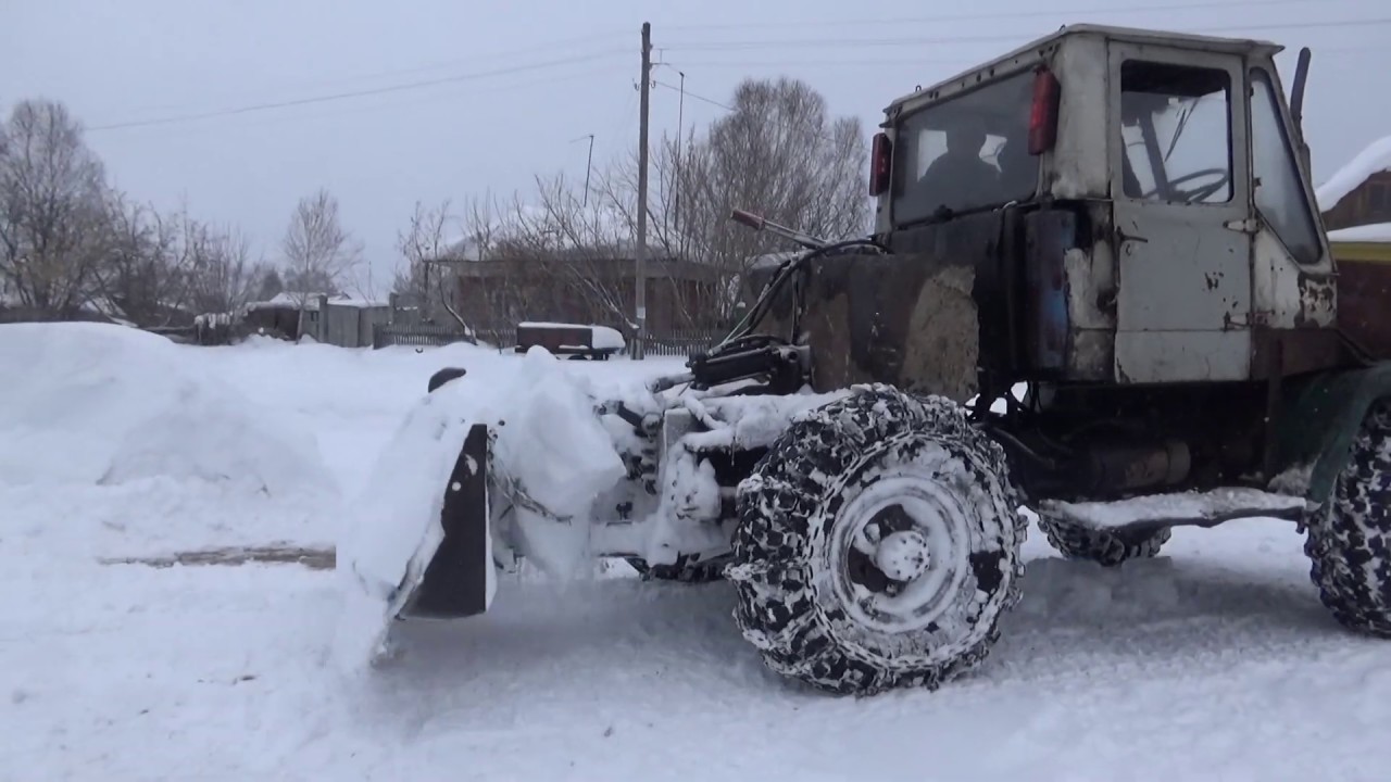 Трактор с дровами. Буксует по снегу.