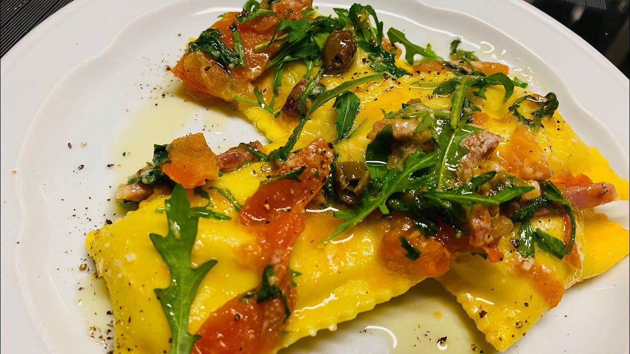 Ravioli lunghi ripieni di ricotta gorgonzola radicchio e noci. conditi con speck pomodori rucola .
