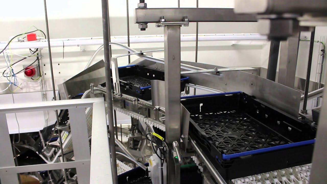Conveyors and bail arm turning for stacking plastic crates