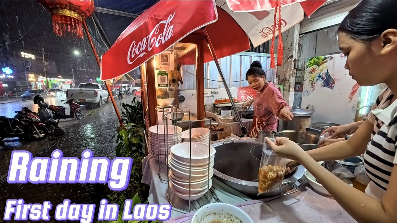 Walking in the rain to the hotel / go eat duck noodles first day in Laos 