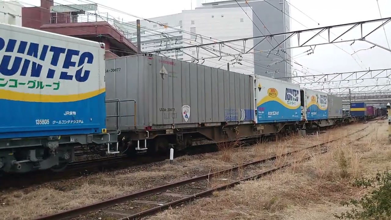 2026年2/15、JR山陽本線広島駅付近(大須賀カーブ)下り遅れ貨物列車【1051列車(東京タ→福岡タ)】〈牽引〉EF210-325【吹】ランテックロボコンテナあり、お手振り👋時、サービス汽笛あり。