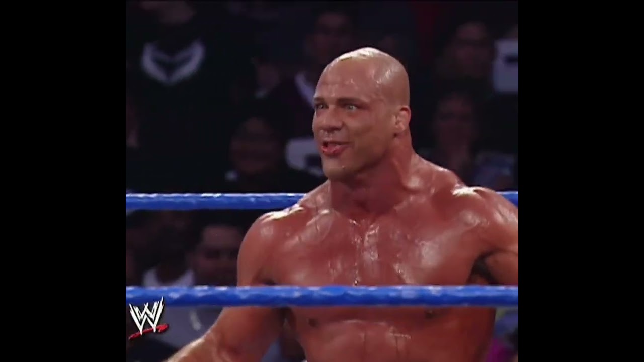 Kurt Angle shoots a tranquilizer dart at The Big Show.