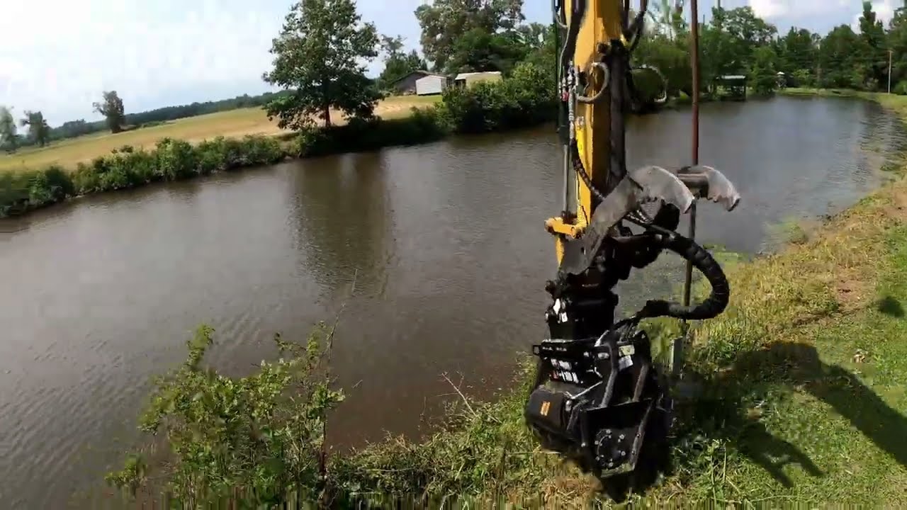 Mulching around a pond with a Cat 309