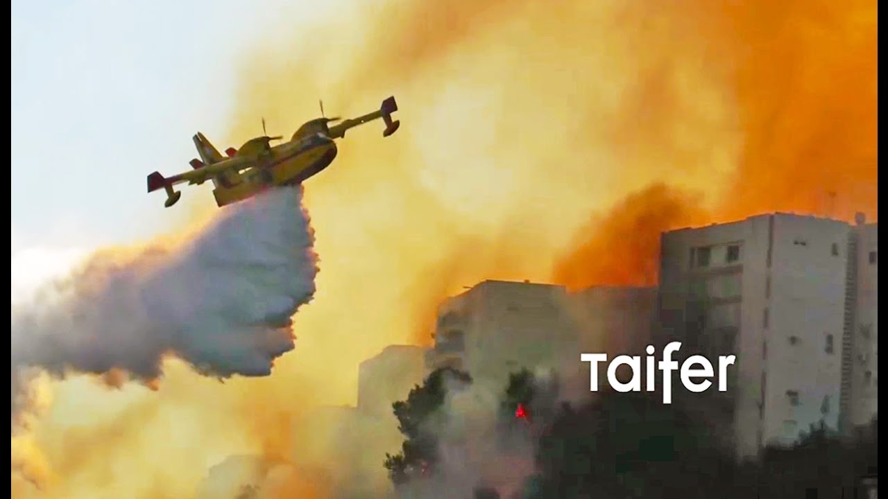 Greek Canadair planes fly between buildings to fight fires in Israel