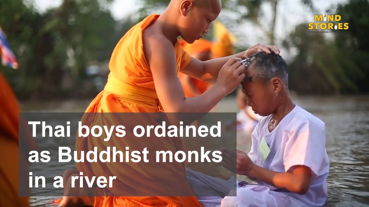 Thai boys ordained as novice Buddhist monks in a river.