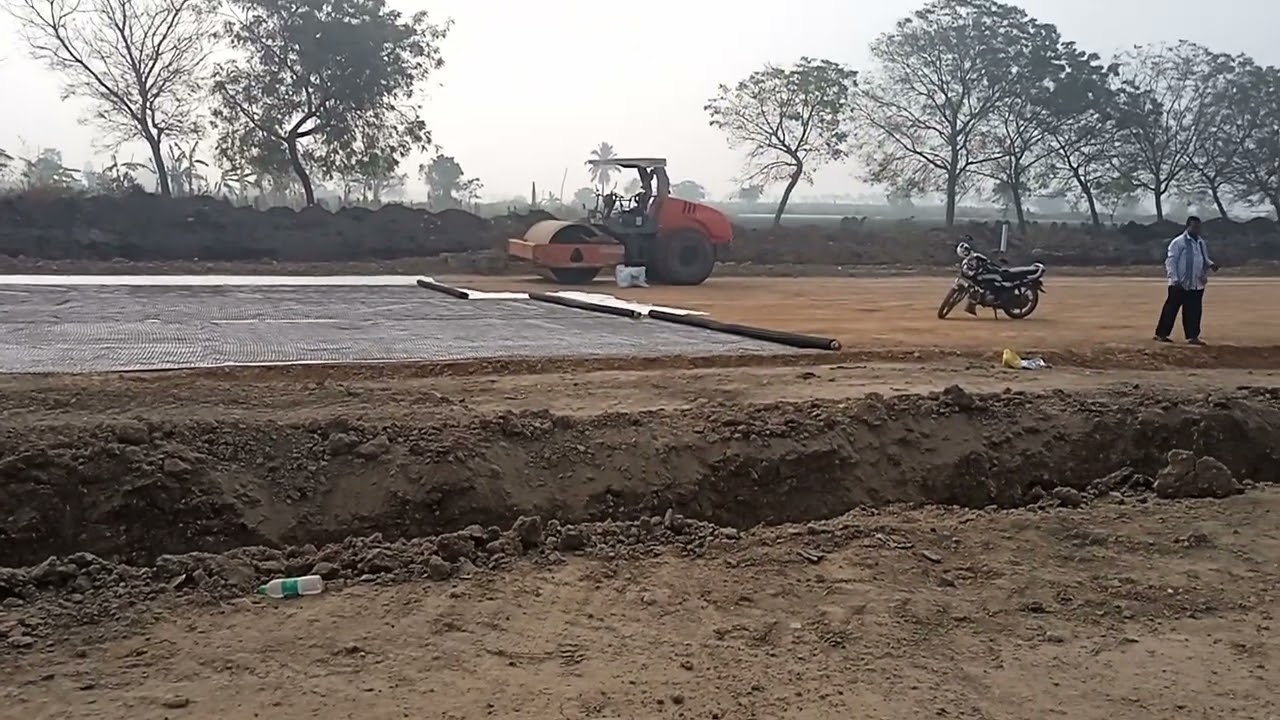 Placing geosynthetics (geotextile and geogrid) beneath the base course over the prepared subgrade.