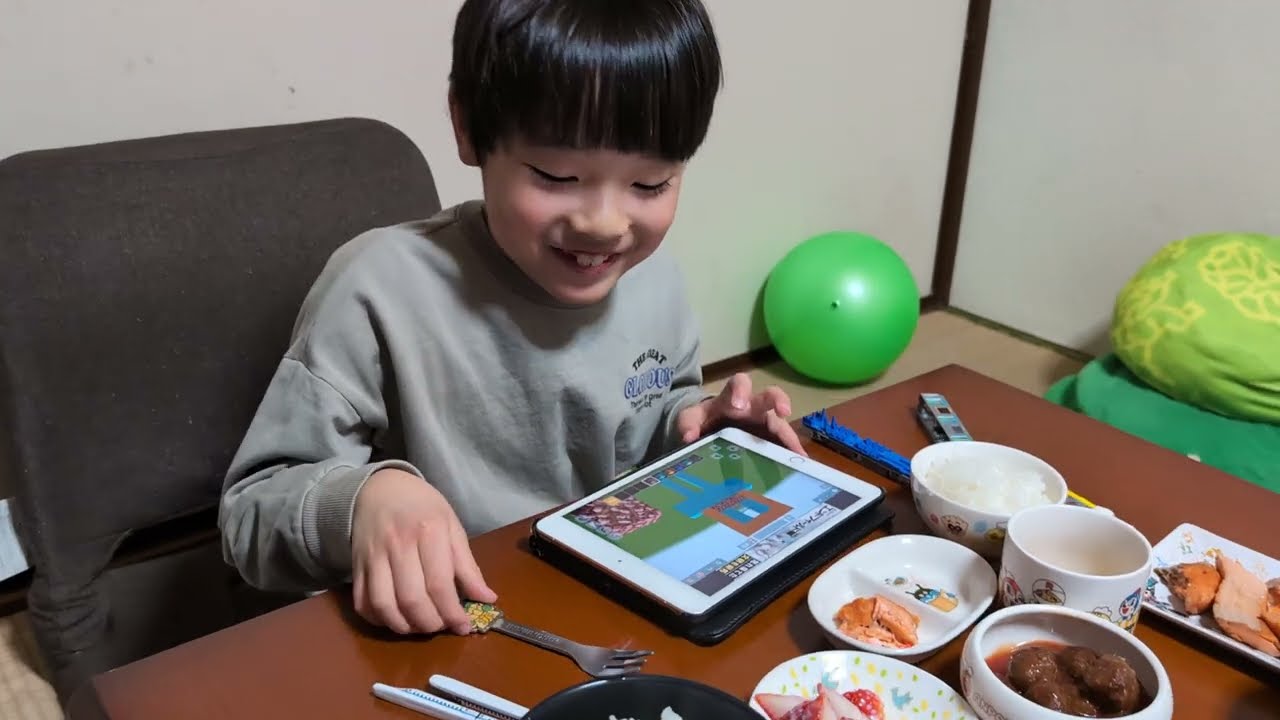 西武線のNゲージ車両を隣に置いて苺を食べながらマインクラフトをプレイしているたっくん。Seibu Line N gauge train. Minecraft. 2026年1月28日。