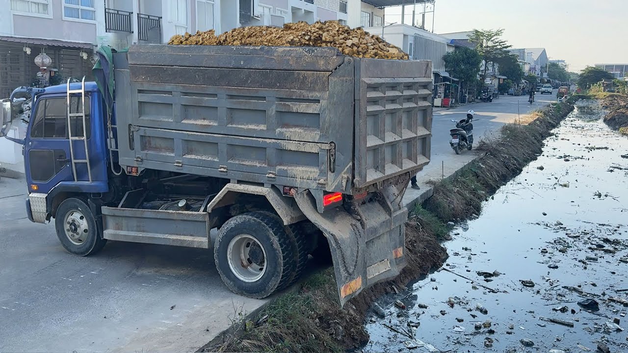 Skillful Operator using NISSAN trucks transport Stone fill delete flooded garbage & push by DOZER