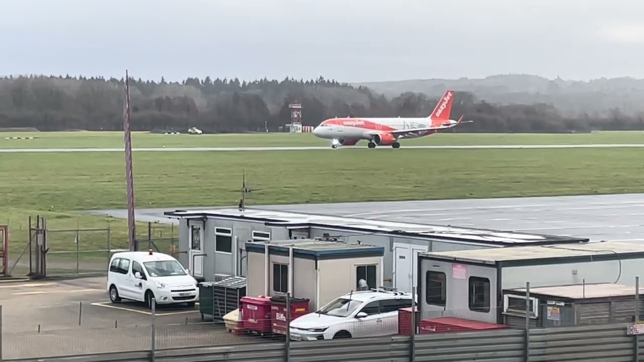 Самолеты EasyJet A320 Neo и Aurigny Dornier-228 вылетают из аэропорта Саутгемптона. Мокрая взлетн...