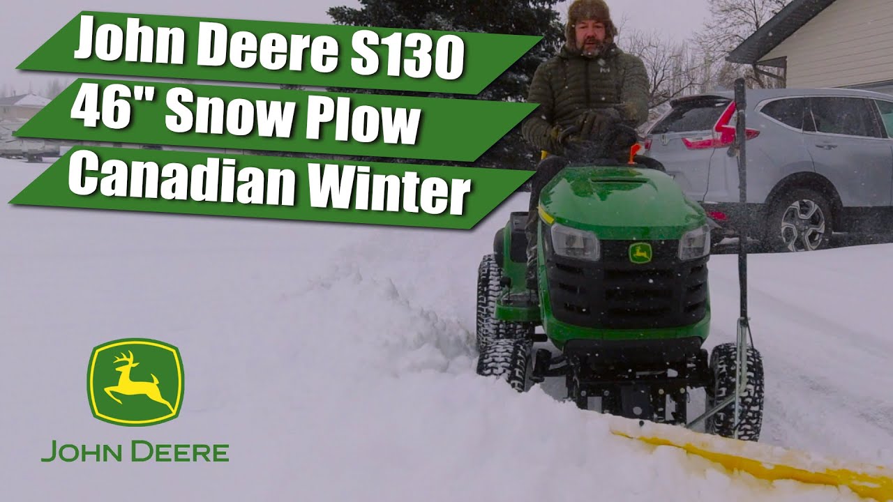 Трактор John Deere S130 со снегоочистителем убирает снег