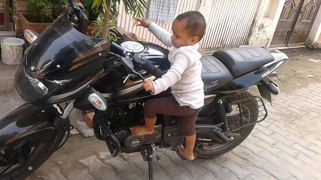 Small boy riding a bike pulser 180cc