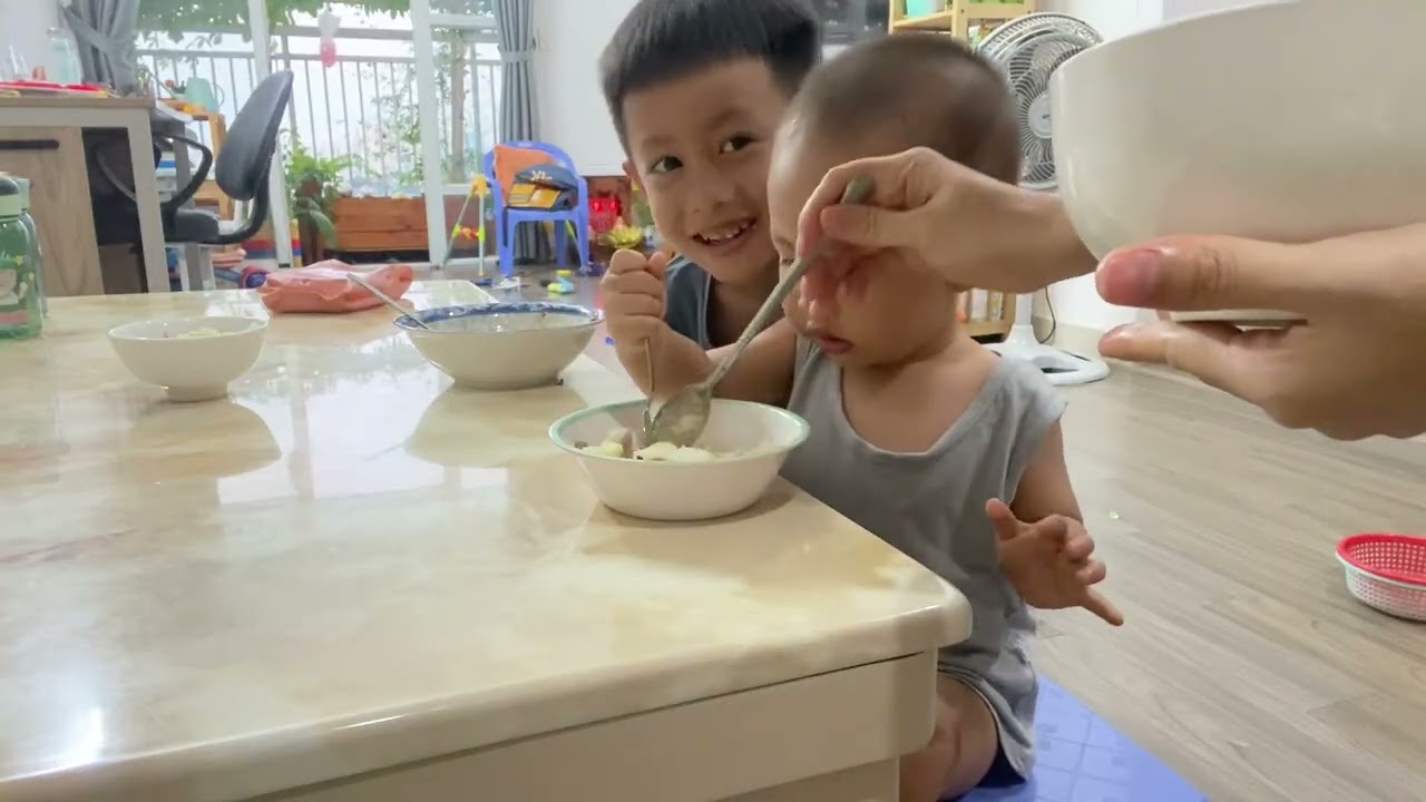 Út Khoa ngồi vào bàn ăn cơm cùng với anh Hai