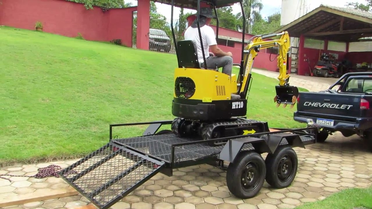 Carregando mini escavadeira na carreta basculante
