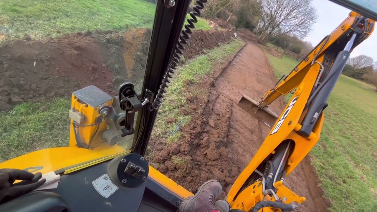 JCB 4cx копает по сельскохозяйственной дороге