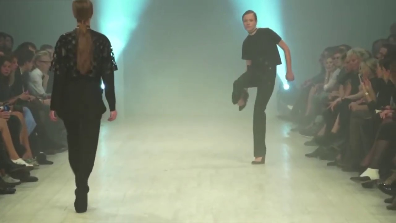 2 Models trip and remove their shoes during a 2018 fashion show
