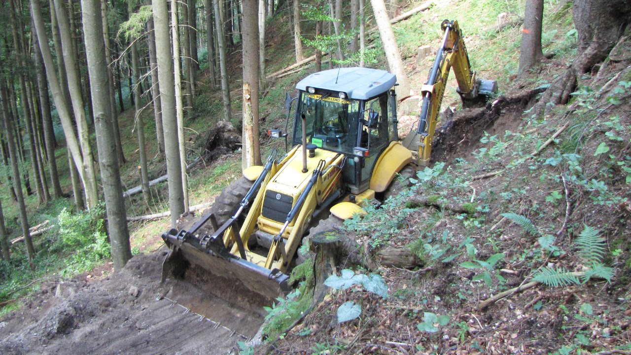New Holland LB 115.B backhoe digging forest road II.