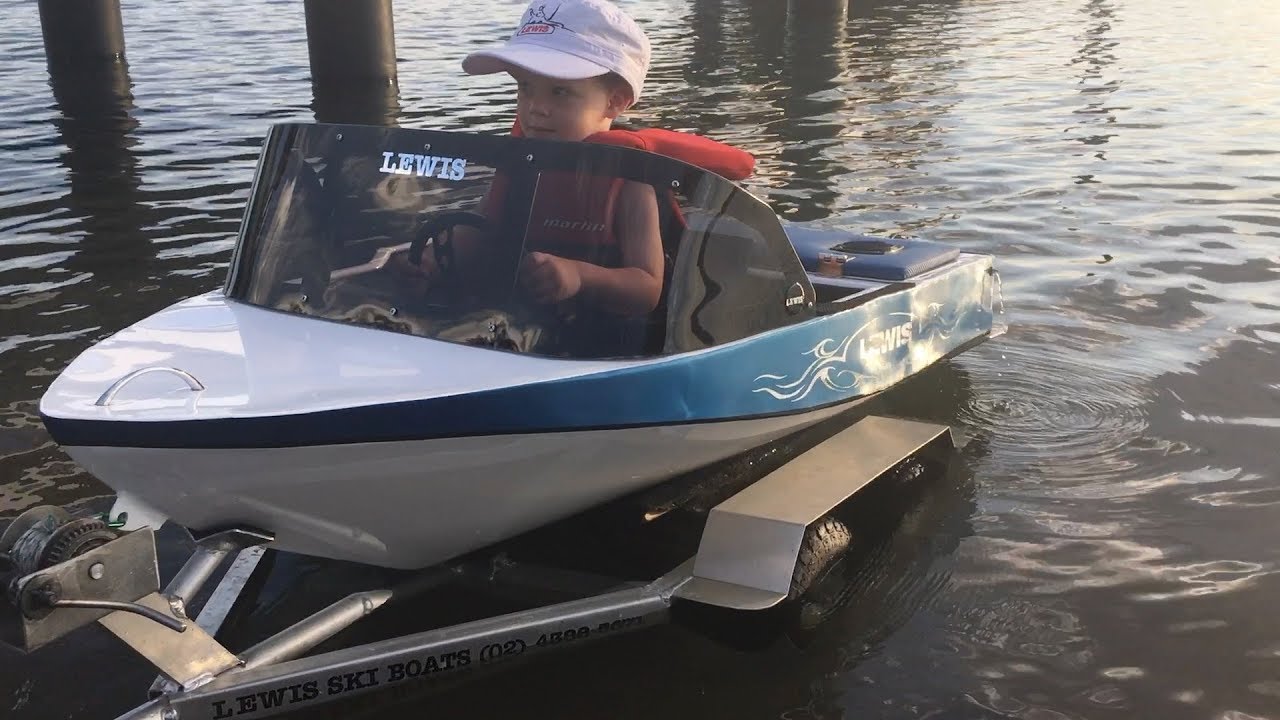 Two year old drives his own mini petrol powered speed boat.