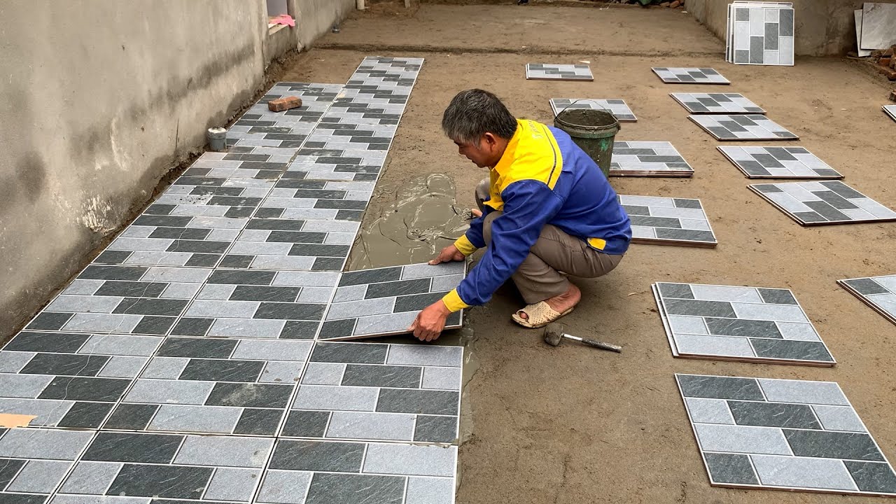 Installation Of 50x50cm Patterned Ceramic Tiles For The Outdoor Playground Of The House.