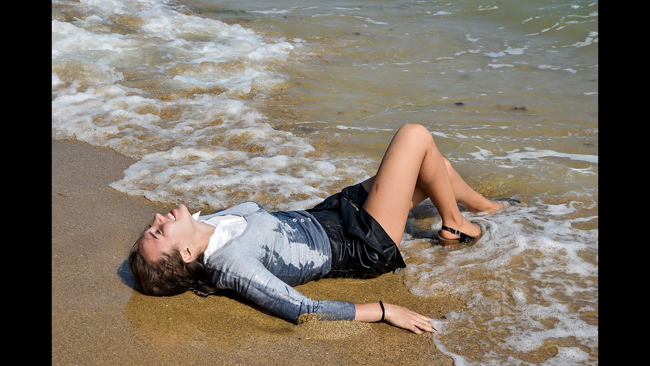 beautiful girl after work in the office tenderly poses on the beach by the sea for wetlook video