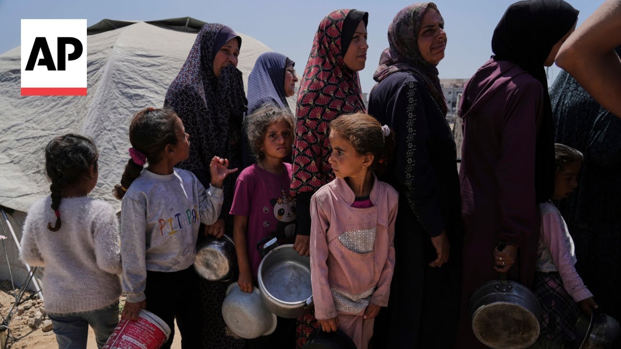 Displaced Palestinians in Gaza City wait to get their share of food for the day