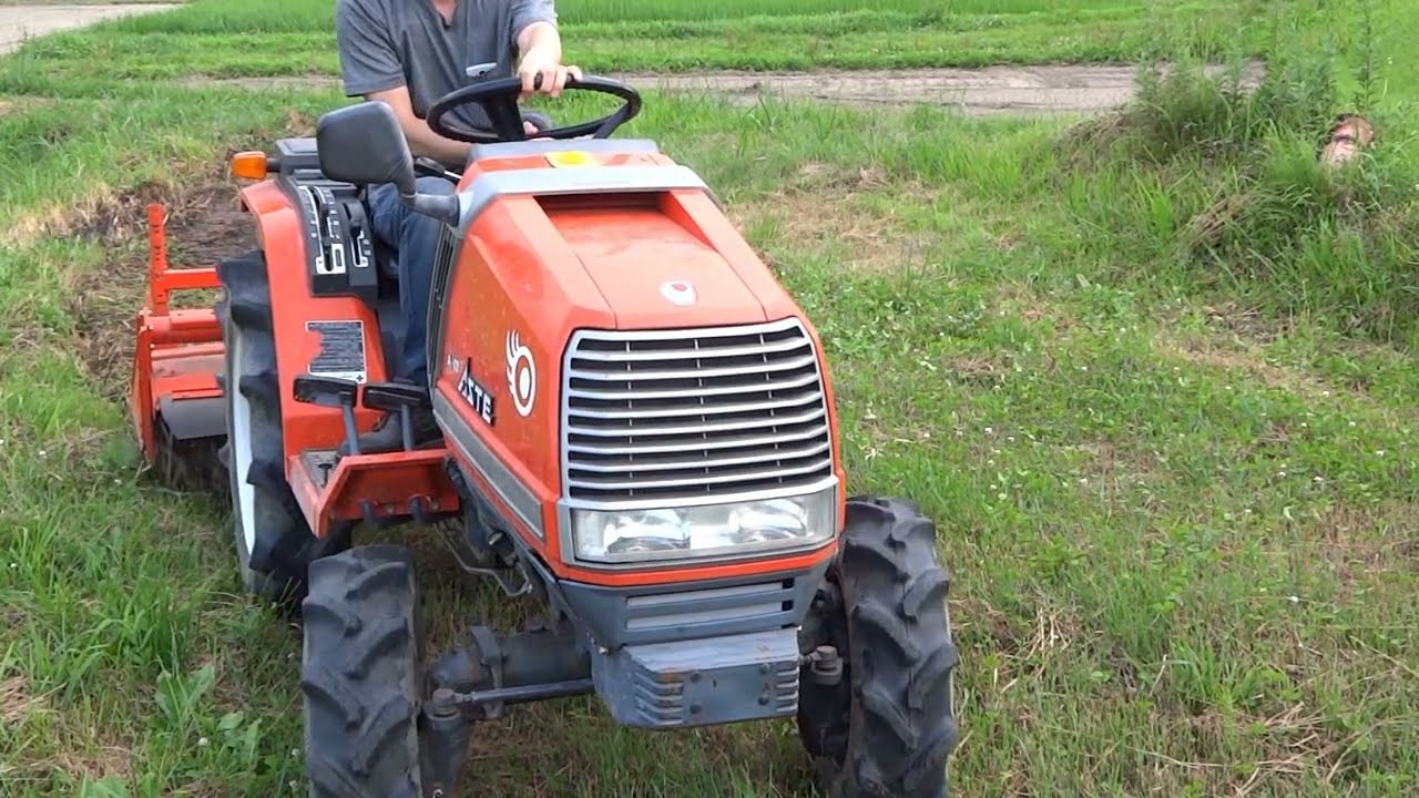 雑草が茂る小さい畑を小さいトラクターでフォーマット